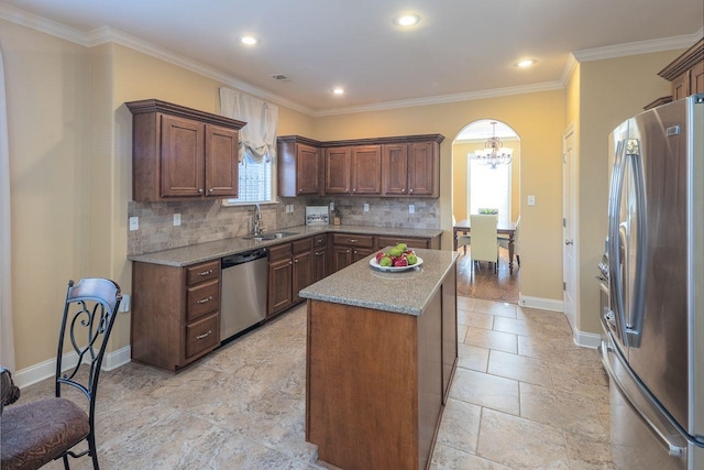 kitchen featuring backsplash, stainless steel appliances, a kitchen island, and crown molding