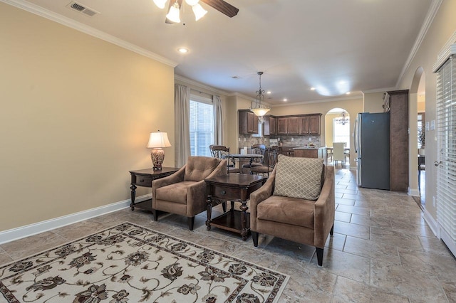 living room featuring ceiling fan and crown molding