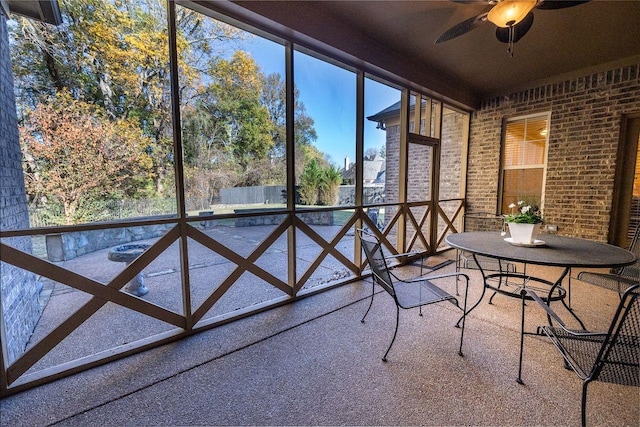 unfurnished sunroom with ceiling fan