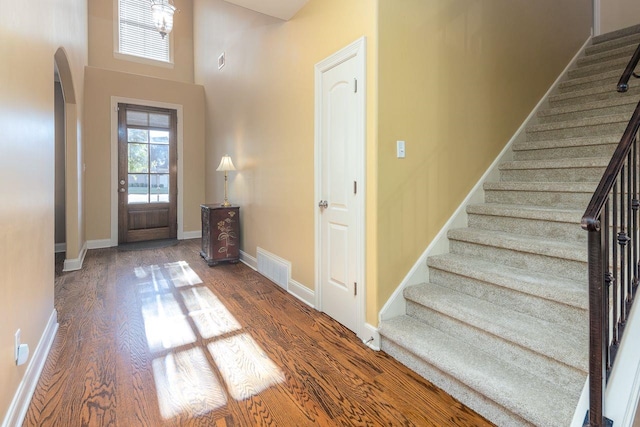 foyer entrance with hardwood / wood-style floors and a high ceiling