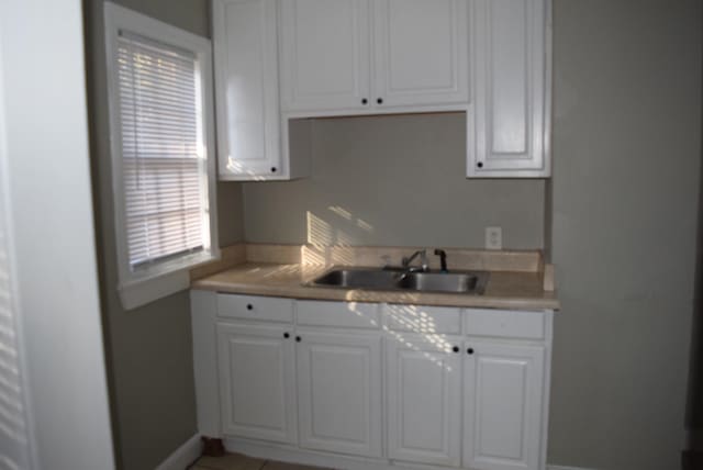 kitchen with white cabinetry and sink