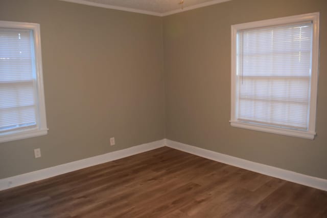 unfurnished room featuring dark hardwood / wood-style floors and ornamental molding