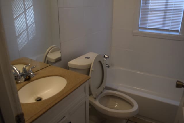 full bathroom with tile walls, vanity, bathtub / shower combination, and toilet