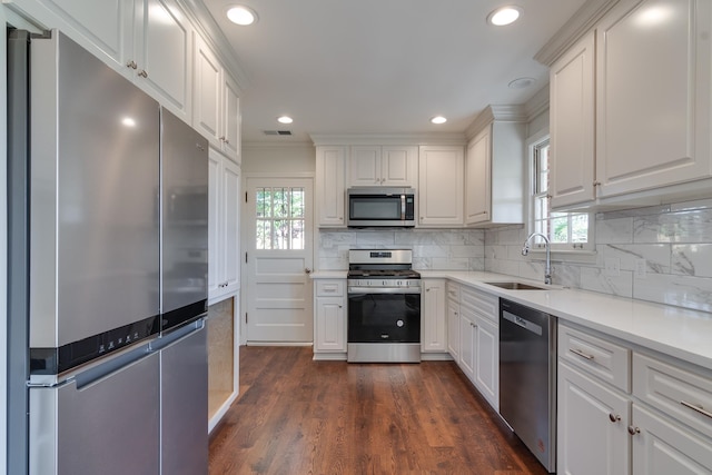 kitchen with a wealth of natural light, white cabinets, and stainless steel appliances