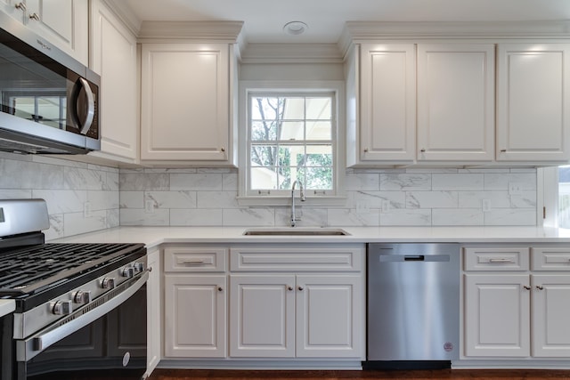 kitchen with decorative backsplash, sink, white cabinets, and stainless steel appliances