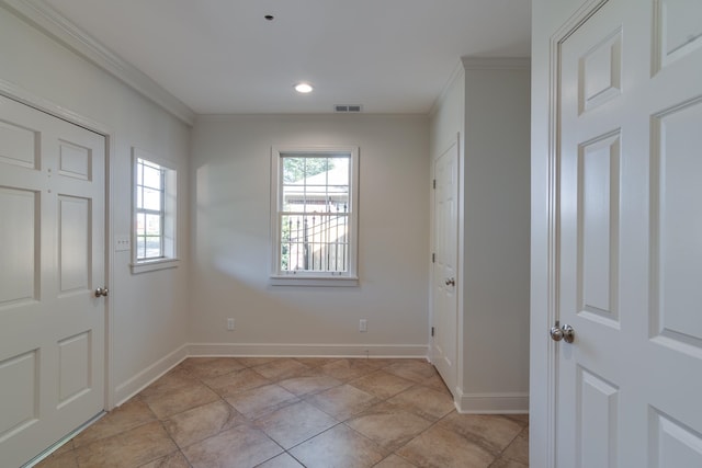 tiled foyer entrance featuring crown molding