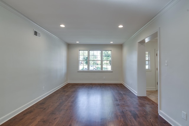 spare room with ornamental molding and dark wood-type flooring