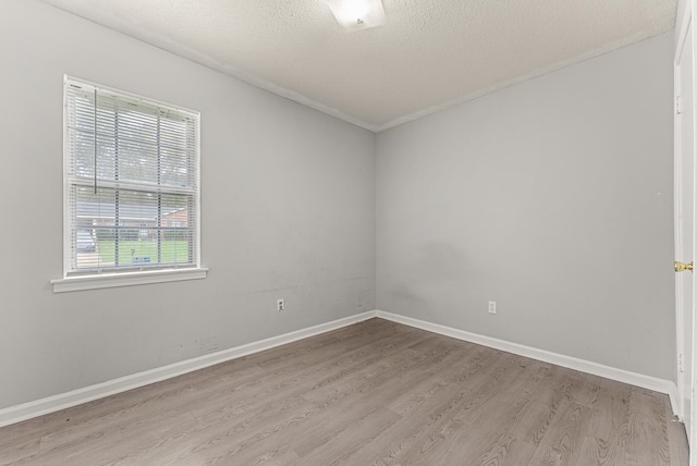 spare room with light hardwood / wood-style floors and a textured ceiling