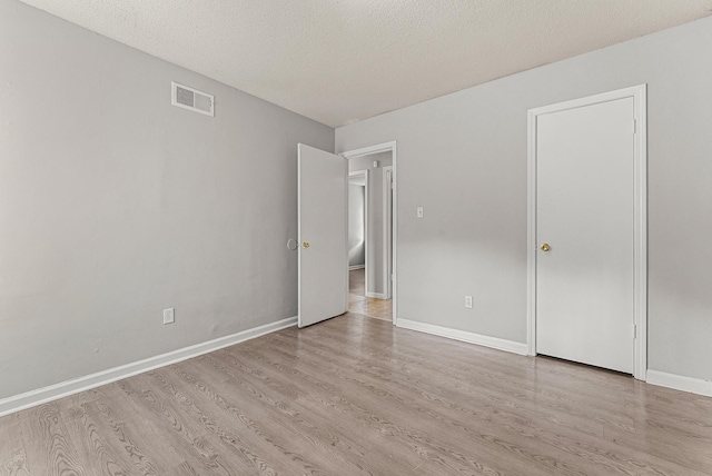 unfurnished bedroom featuring light hardwood / wood-style flooring and a textured ceiling