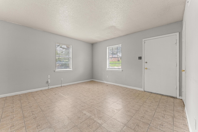 spare room with a wealth of natural light and a textured ceiling