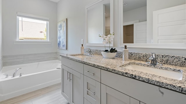 bathroom with vanity and a bath