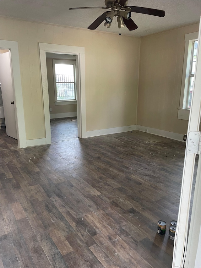 unfurnished room featuring ceiling fan, dark hardwood / wood-style flooring, and a textured ceiling