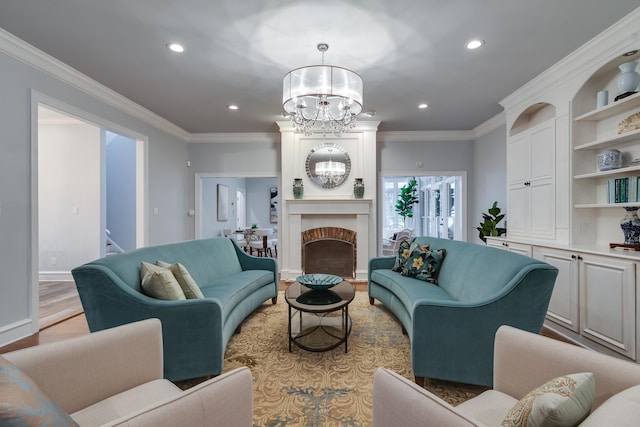 living room featuring a chandelier, light wood-type flooring, a fireplace, and crown molding