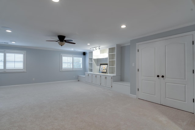 unfurnished living room with light colored carpet, ceiling fan, and crown molding