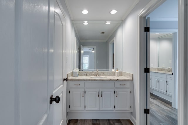 bathroom with wood-type flooring, vanity, and crown molding