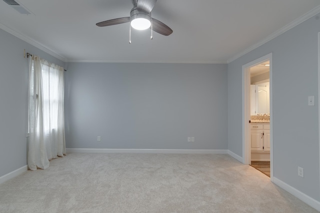 spare room featuring ceiling fan, crown molding, and light carpet