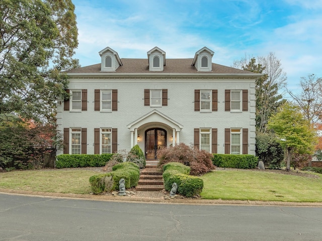 colonial inspired home with a front lawn