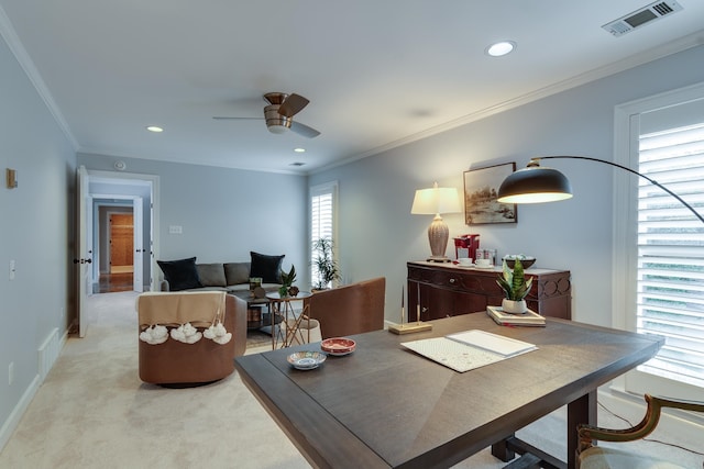 dining room featuring light carpet, ceiling fan, and crown molding