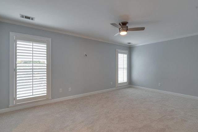 carpeted spare room featuring plenty of natural light, crown molding, and ceiling fan