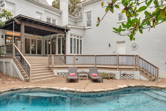 rear view of property featuring a patio area and a sunroom