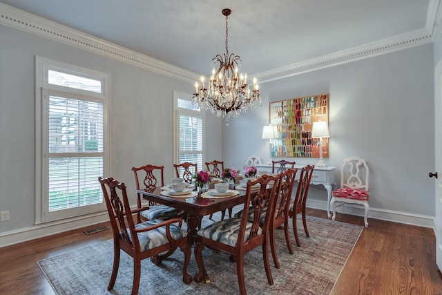 dining area featuring crown molding, dark hardwood / wood-style floors, and an inviting chandelier