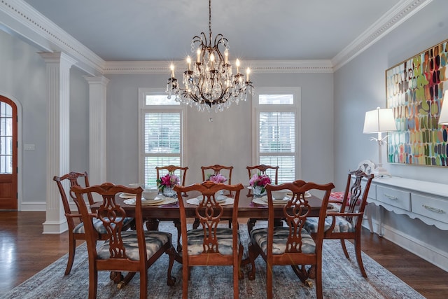 dining room with decorative columns, dark hardwood / wood-style flooring, ornamental molding, and a chandelier