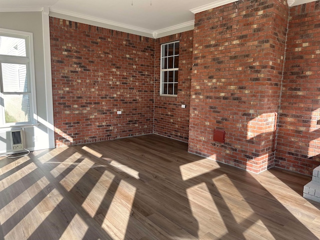 unfurnished room with a wealth of natural light, crown molding, and wood-type flooring