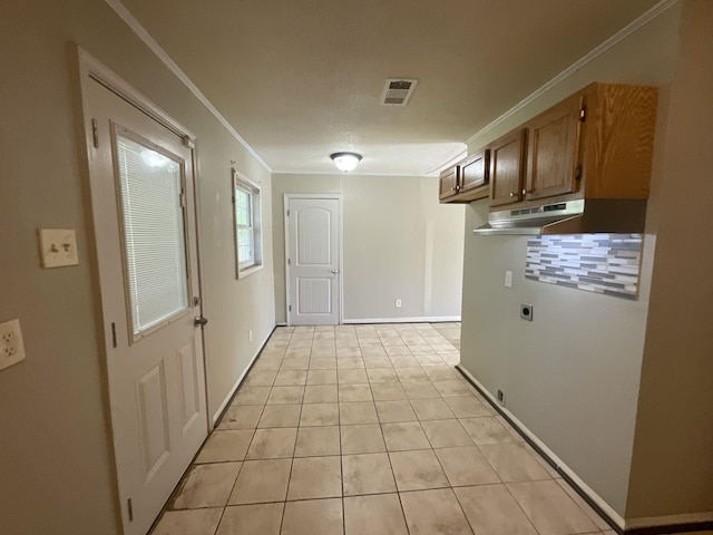 hall with light tile patterned floors and ornamental molding