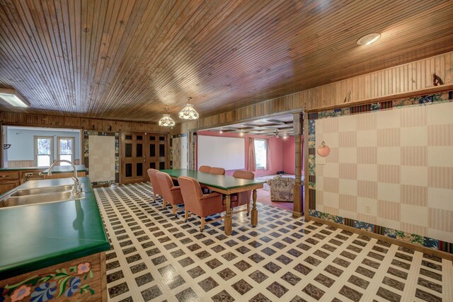 interior space featuring hanging light fixtures, plenty of natural light, wood ceiling, and sink