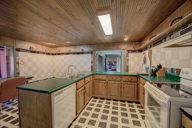 kitchen featuring kitchen peninsula, white appliances, and sink