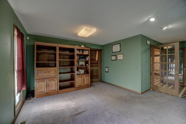 interior space featuring light carpet and a textured ceiling