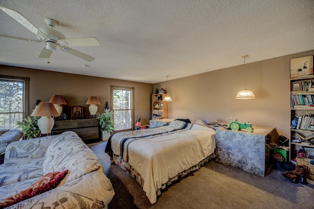 bedroom featuring carpet flooring, ceiling fan, and a textured ceiling