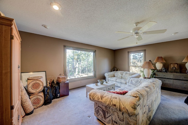 carpeted living room with ceiling fan and a textured ceiling