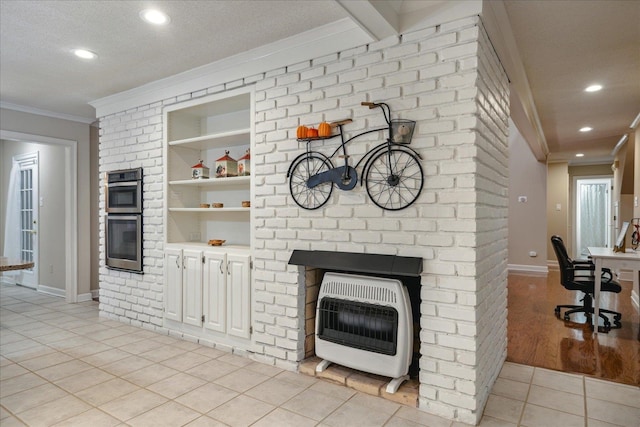 tiled living room with built in shelves, a textured ceiling, heating unit, and ornamental molding