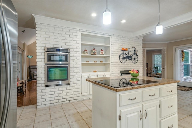 kitchen with hanging light fixtures, light tile patterned floors, appliances with stainless steel finishes, white cabinets, and ornamental molding