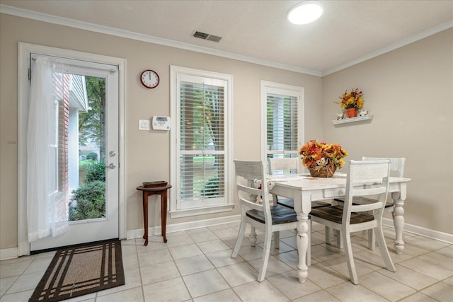 dining area with a textured ceiling, light tile patterned floors, and crown molding