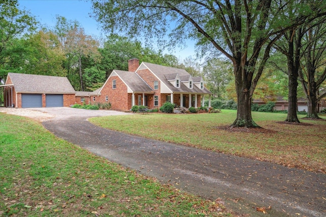 view of front of home featuring an outbuilding, a garage, and a front lawn