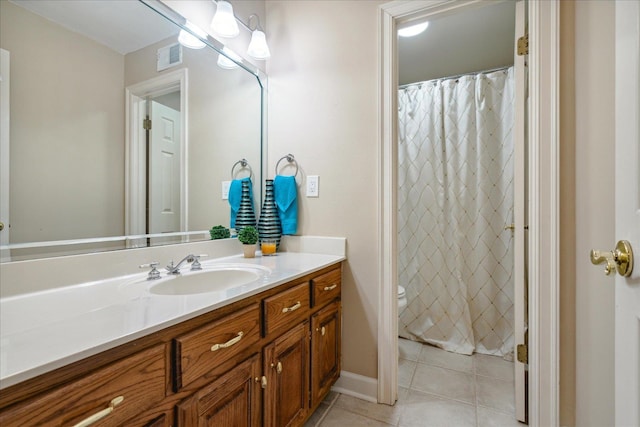 bathroom with tile patterned flooring, vanity, and toilet