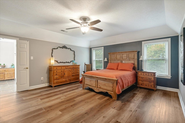 bedroom featuring ceiling fan, wood-type flooring, and a textured ceiling