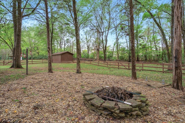 view of yard with an outdoor fire pit and a storage unit