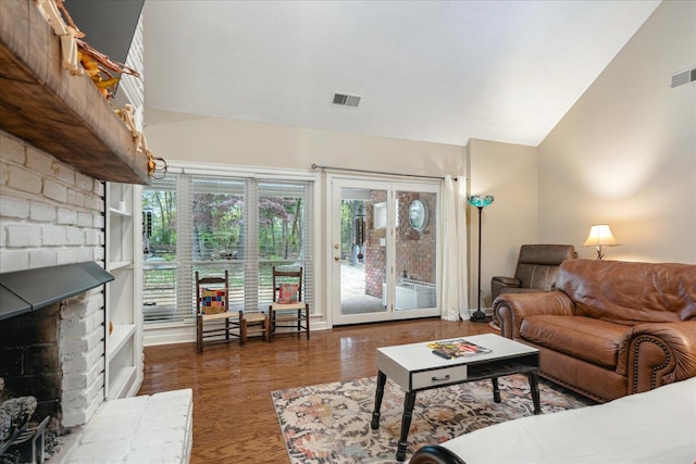 living room with a fireplace, lofted ceiling, and dark wood-type flooring