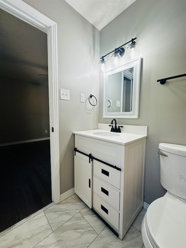 bathroom with vanity, a textured ceiling, and toilet