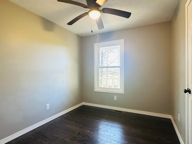 empty room featuring a textured ceiling, ceiling fan, and dark hardwood / wood-style floors