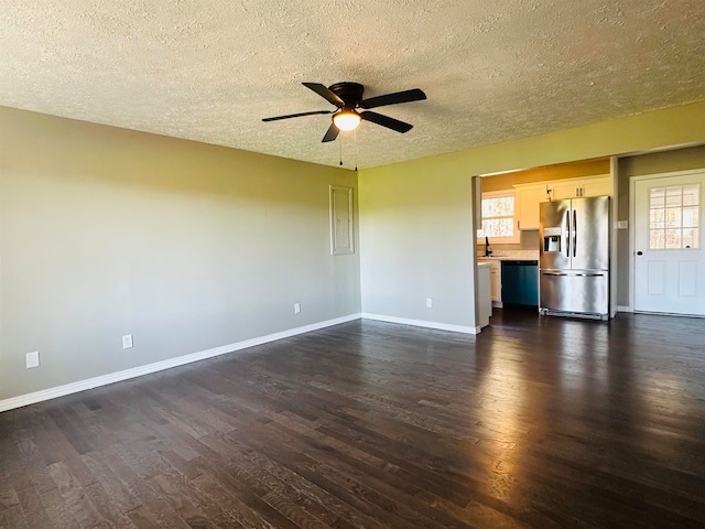 unfurnished living room featuring ceiling fan, sink, dark wood-type flooring, and a textured ceiling