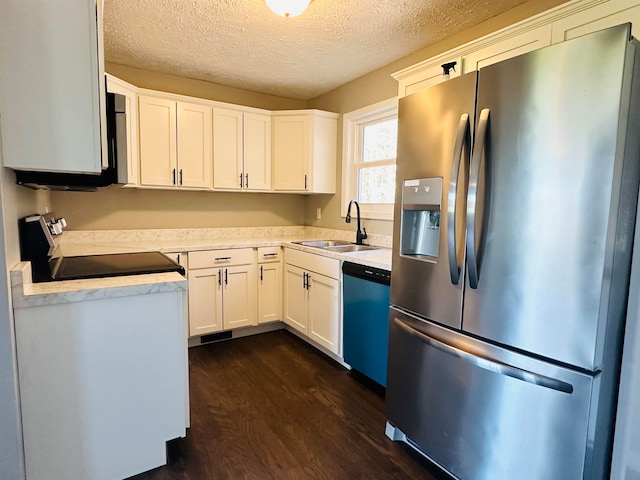 kitchen featuring appliances with stainless steel finishes, dark hardwood / wood-style flooring, a textured ceiling, sink, and white cabinets