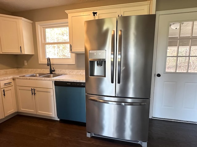 kitchen featuring sink, dark hardwood / wood-style flooring, a textured ceiling, white cabinets, and appliances with stainless steel finishes