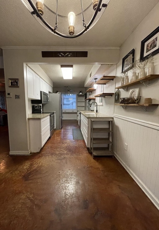 kitchen with a textured ceiling, stainless steel appliances, crown molding, sink, and white cabinets