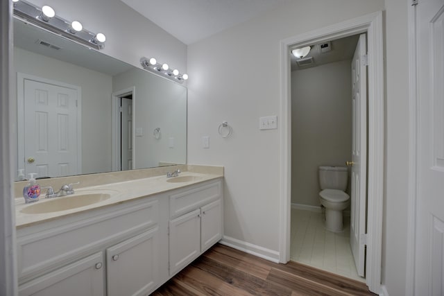 bathroom featuring hardwood / wood-style floors, vanity, and toilet