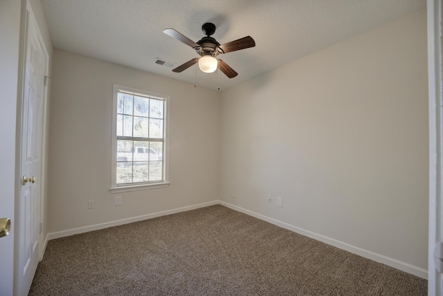 carpeted spare room featuring a textured ceiling and ceiling fan