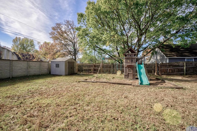 view of yard featuring a storage unit and a playground